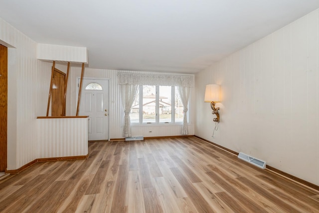 foyer entrance with hardwood / wood-style floors and wood walls