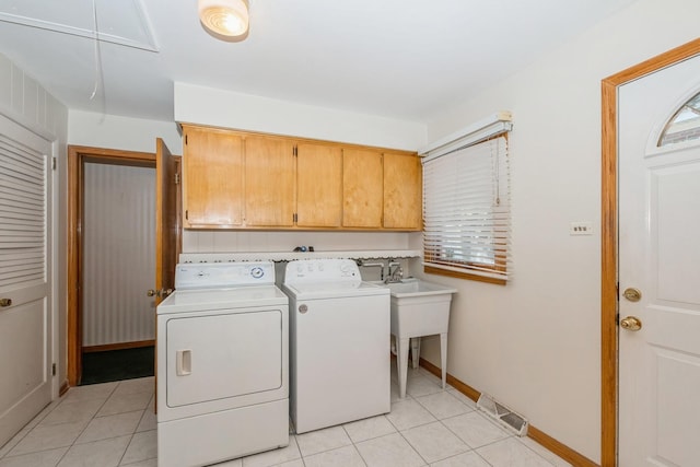 laundry room featuring cabinets, washing machine and dryer, and light tile patterned floors