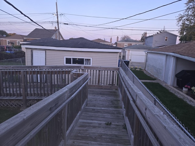 deck at dusk featuring an outdoor structure