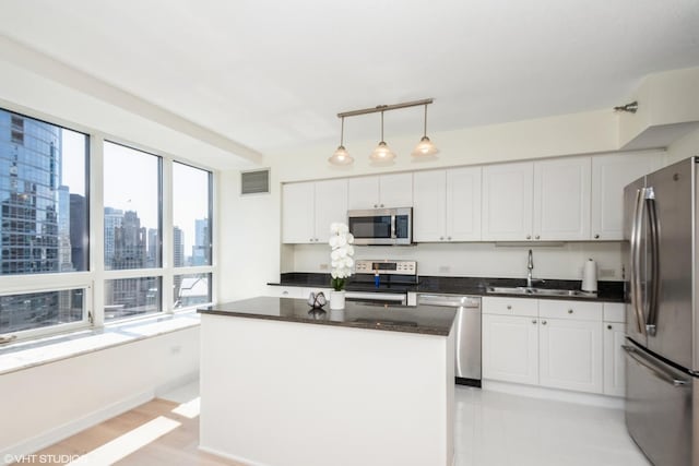 kitchen featuring a kitchen island, sink, white cabinetry, and stainless steel appliances