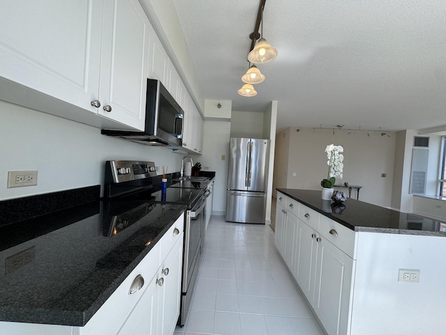 kitchen with white cabinets, pendant lighting, a textured ceiling, and appliances with stainless steel finishes