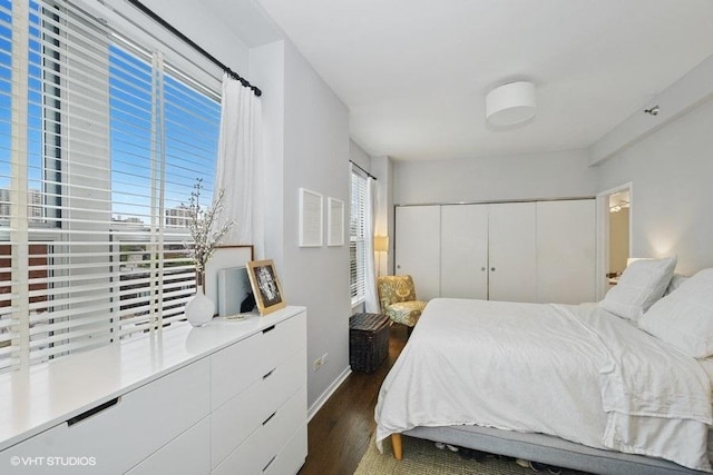 bedroom with dark wood-type flooring and a closet