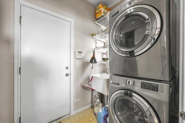 clothes washing area featuring stacked washer and clothes dryer