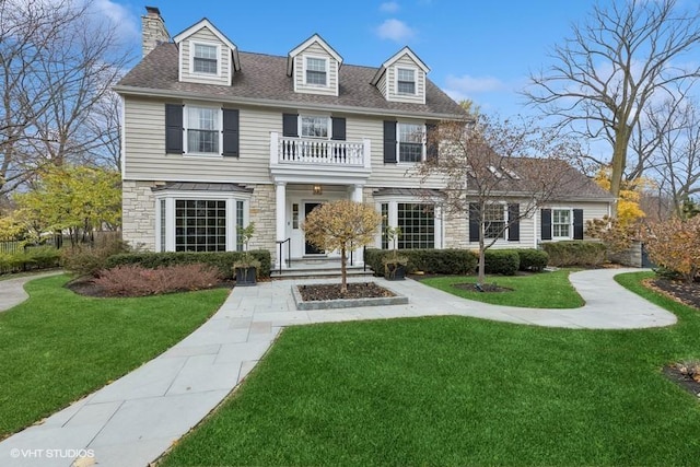 colonial-style house with a front yard and a balcony