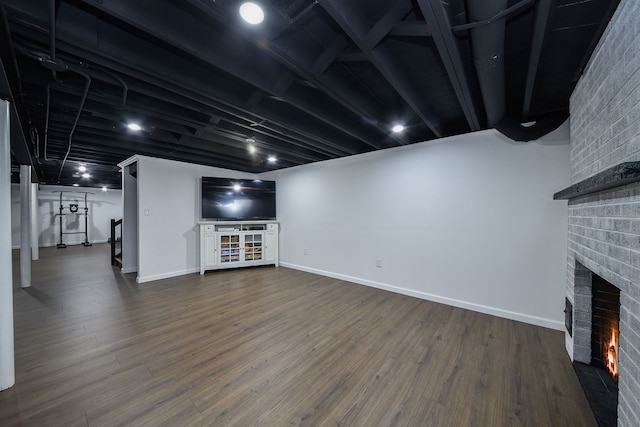 unfurnished living room featuring dark wood-type flooring, a fireplace, and baseboards