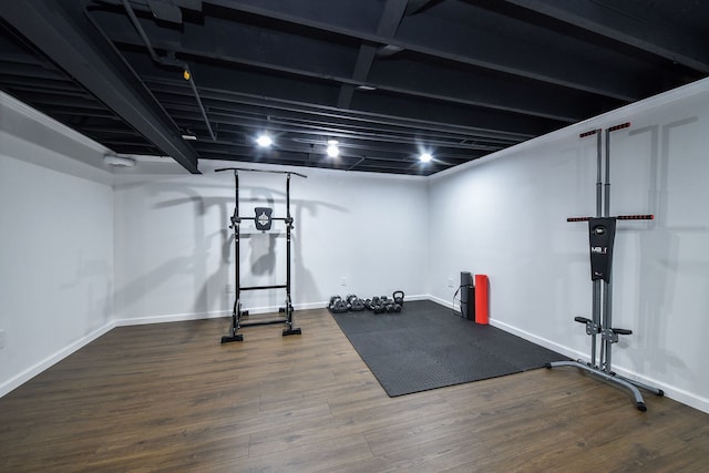 exercise room with baseboards and wood finished floors