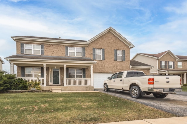 view of front of property featuring a porch, a garage, and a front lawn