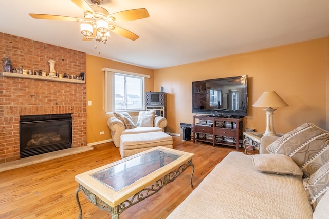 living room with ceiling fan, a fireplace, and hardwood / wood-style flooring