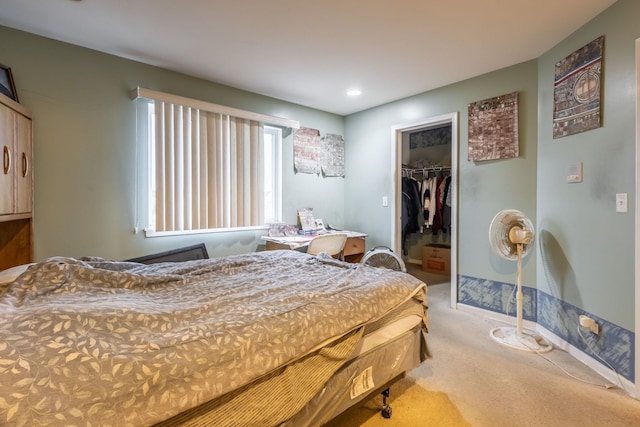 carpeted bedroom with a spacious closet and a closet