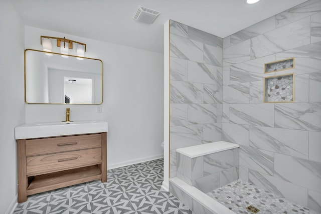 bathroom featuring a tile shower and vanity