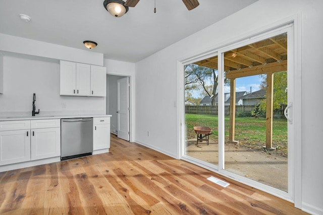 kitchen featuring stainless steel dishwasher, ceiling fan, sink, white cabinets, and light hardwood / wood-style floors