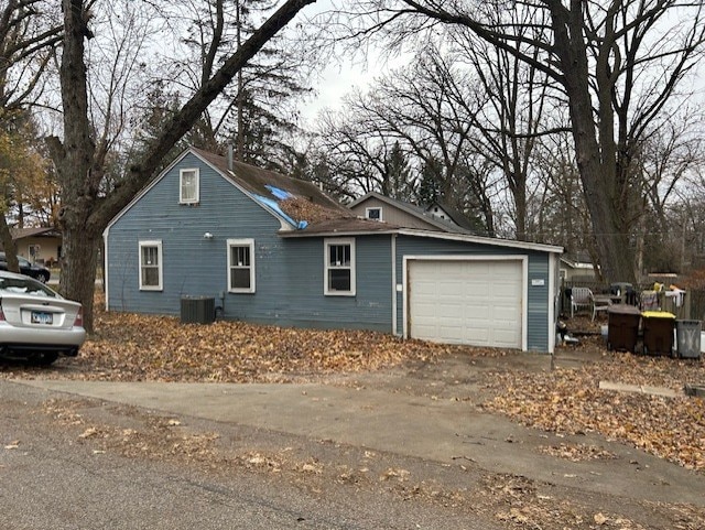 view of property exterior featuring a garage and central AC