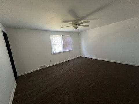 carpeted spare room featuring ceiling fan