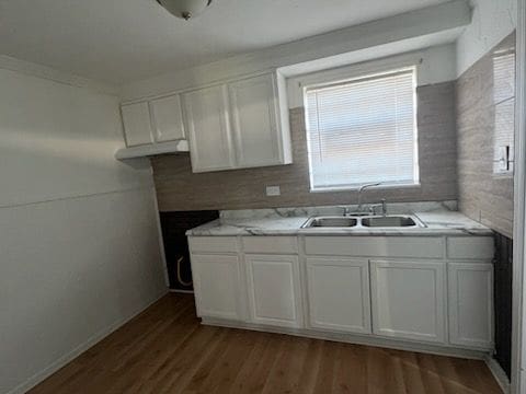 kitchen featuring white cabinets, dark hardwood / wood-style floors, backsplash, and sink