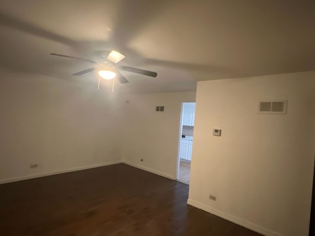 empty room with ceiling fan and dark wood-type flooring