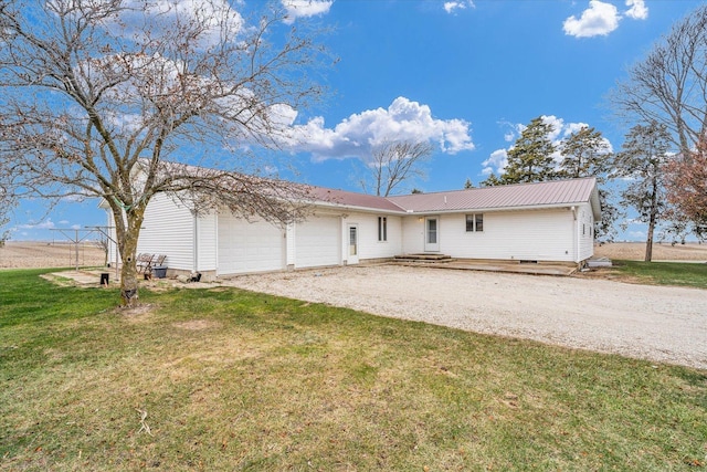 single story home with gravel driveway, metal roof, a garage, and a front lawn