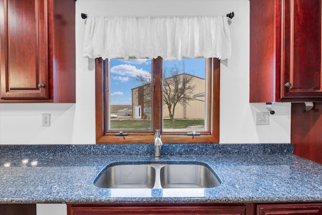 kitchen featuring dark stone countertops and sink