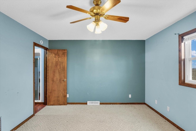 carpeted empty room featuring a textured ceiling and ceiling fan