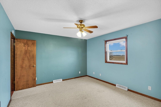 unfurnished room with a ceiling fan, visible vents, and baseboards