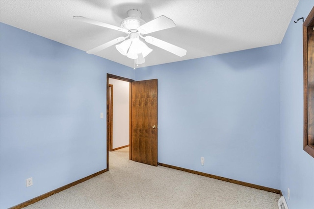 carpeted empty room featuring a textured ceiling, baseboard heating, and ceiling fan