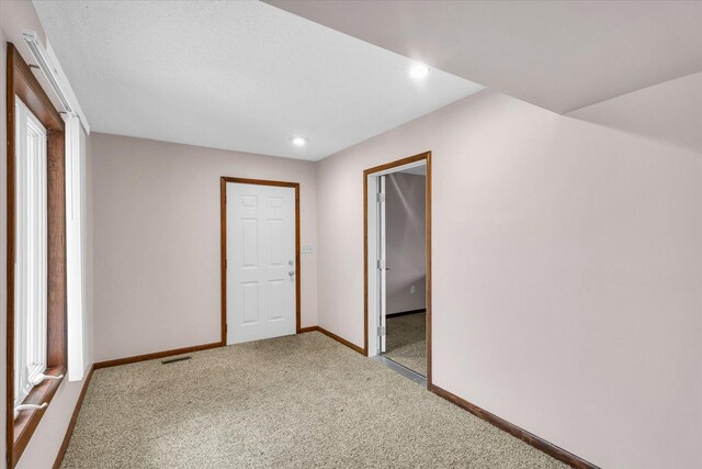 unfurnished bedroom with light colored carpet, a textured ceiling, and a closet