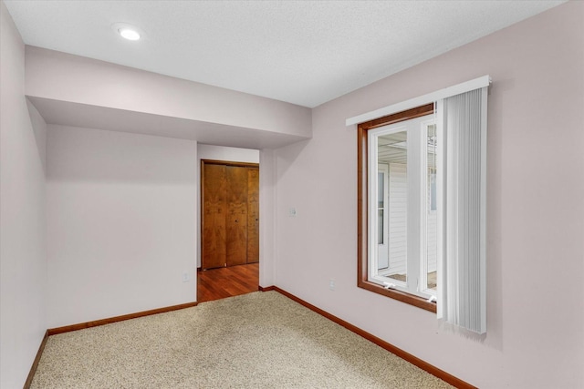 empty room with carpet floors and a textured ceiling