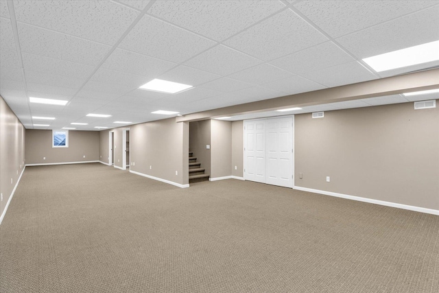 finished basement featuring carpet floors, baseboards, stairs, and visible vents