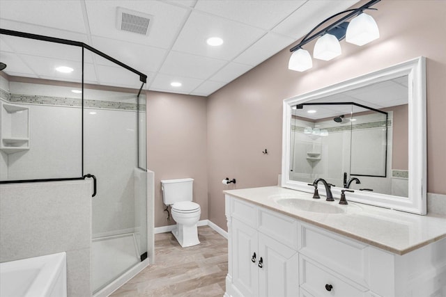 bathroom with a paneled ceiling, an enclosed shower, vanity, hardwood / wood-style flooring, and toilet