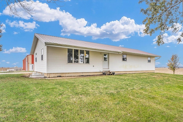 ranch-style house with a front yard, metal roof, and entry steps