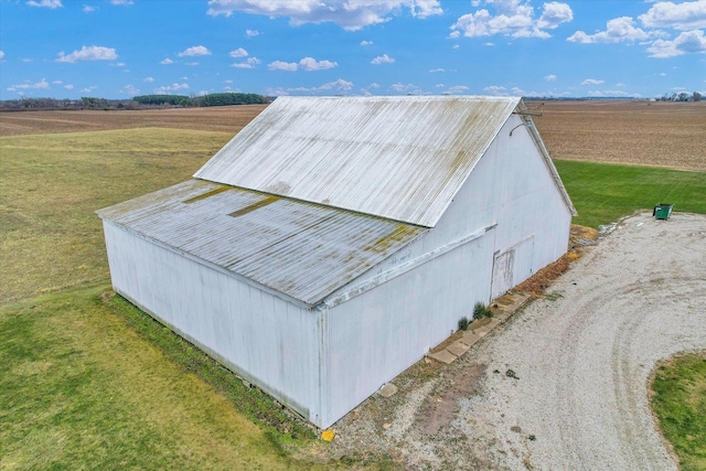 entry to storm shelter with a rural view, a yard, and an outdoor structure