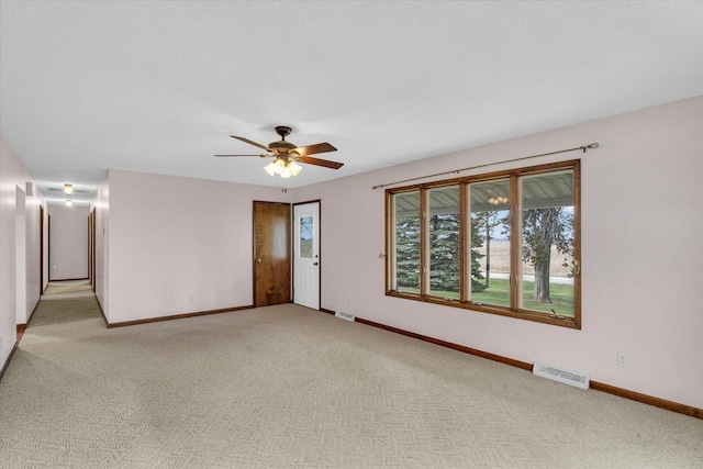 unfurnished room featuring a textured ceiling, ceiling fan, and light carpet