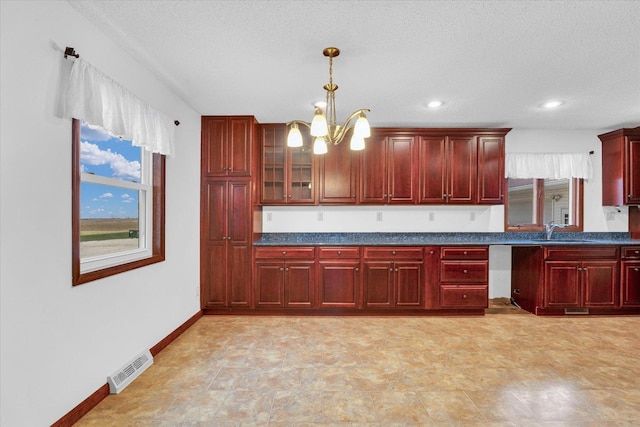 kitchen featuring a healthy amount of sunlight, sink, hanging light fixtures, and a chandelier