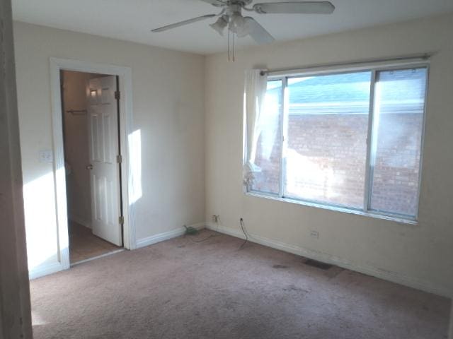 spare room featuring light colored carpet and ceiling fan