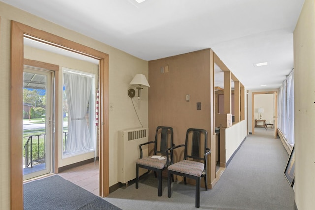 corridor featuring radiator heating unit and light colored carpet