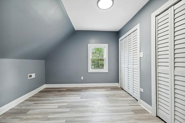 bonus room with light hardwood / wood-style floors and vaulted ceiling