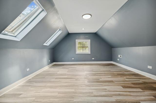 bonus room featuring light wood-type flooring and vaulted ceiling