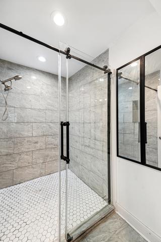 bathroom with a shower with door