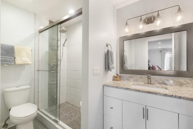 bathroom featuring vanity, toilet, and a shower with shower door