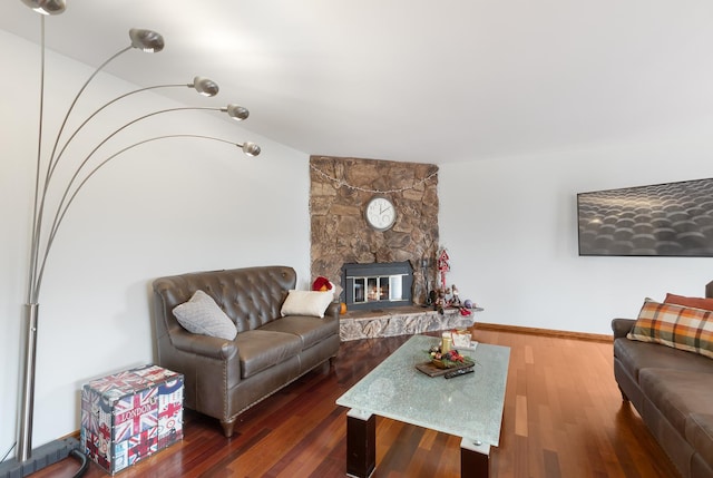 living room with hardwood / wood-style flooring and a stone fireplace