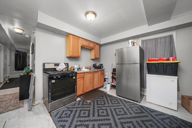 kitchen with black range with electric cooktop, stainless steel refrigerator, refrigerator, and sink