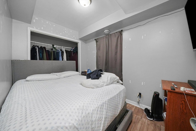 bedroom with a closet and hardwood / wood-style floors