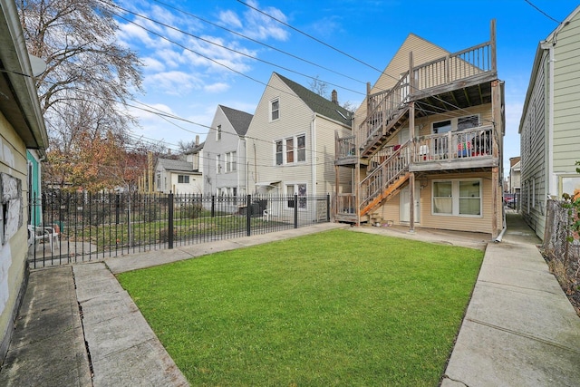 back of property with a balcony and a yard