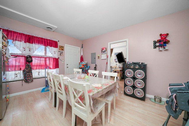 dining space with electric panel and light hardwood / wood-style floors