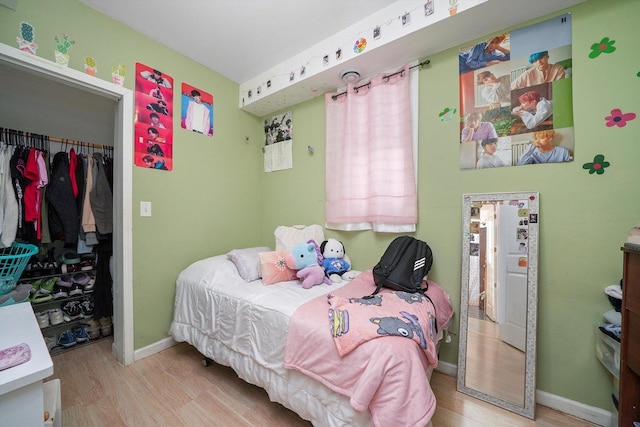 bedroom with light hardwood / wood-style flooring and a closet