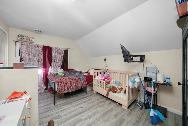 bedroom featuring vaulted ceiling and light wood-type flooring