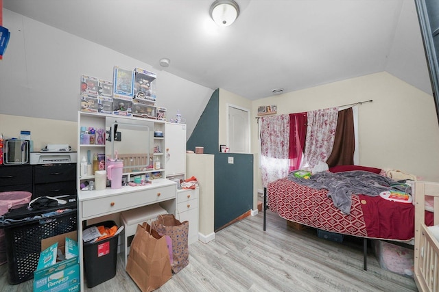 bedroom featuring light hardwood / wood-style flooring and lofted ceiling