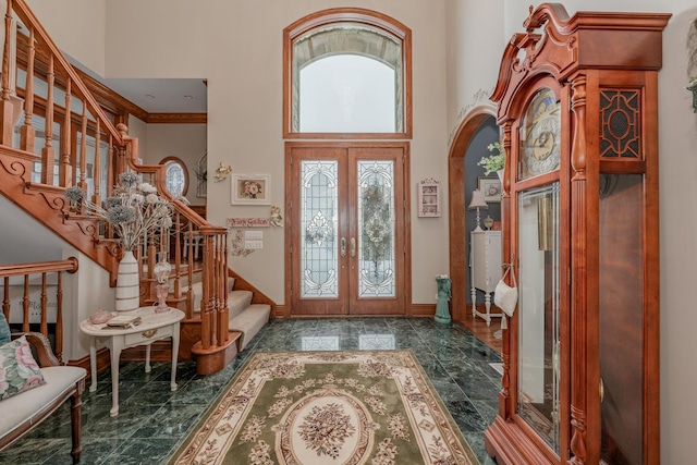 entryway featuring crown molding, french doors, a healthy amount of sunlight, and a high ceiling