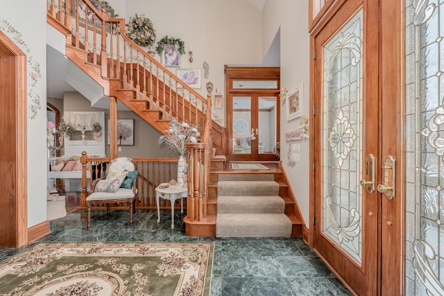 foyer entrance with a high ceiling and french doors