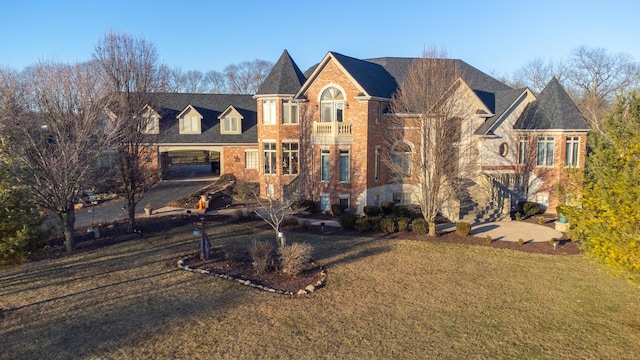 view of front of home with a balcony and a front lawn