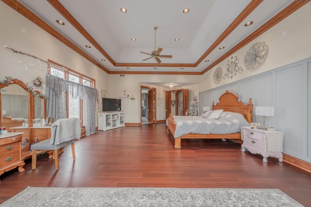 bedroom with a tray ceiling, ceiling fan, dark hardwood / wood-style flooring, and ornamental molding